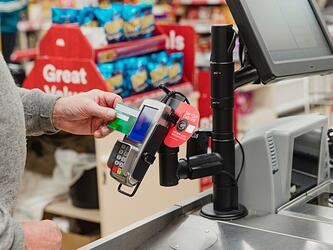 person using card to pay at supermarket till